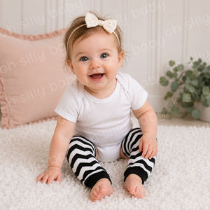 Baby wearing a white short sleeve bodysuit with Black and White Chevron baby leg warmers