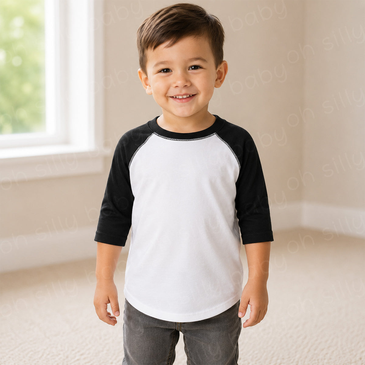 Toddler boy wearing a black and white raglan toddler t-shirt