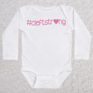 Cleftstrong Heart long sleeve baby bodysuit in white featuring a pink Cleftstrong heart design