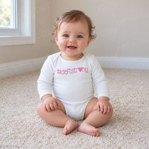 Cleftstrong Heart baby wearing white long sleeve bodysuit with pink #cleftstrong heart design