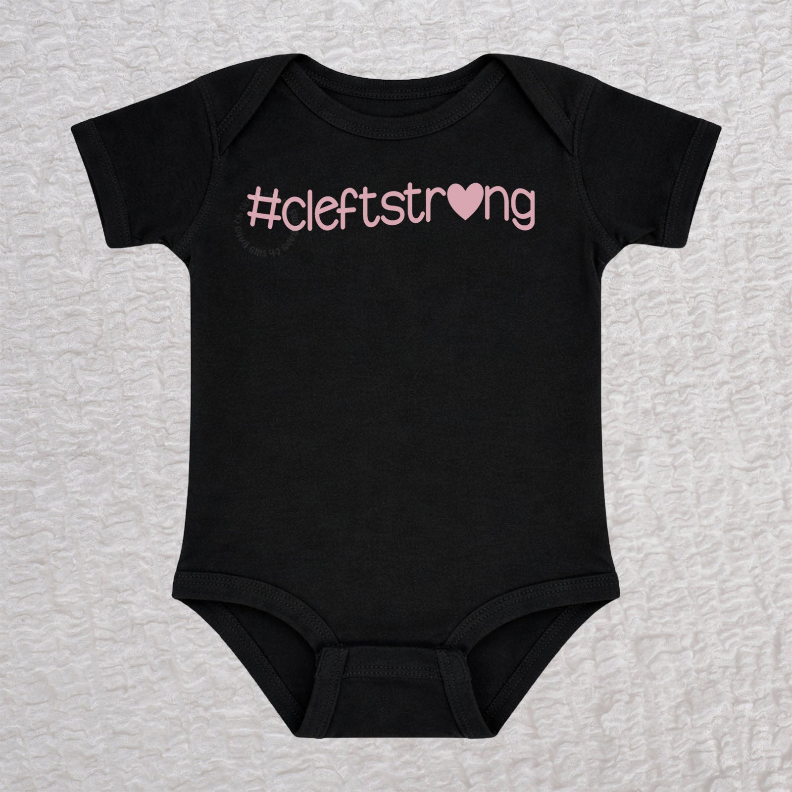 Cleftstrong Heart short sleeve baby bodysuit in black featuring a pink Cleftstrong heart design