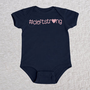 Cleftstrong Heart short sleeve baby bodysuit in navy featuring a pink Cleftstrong heart design