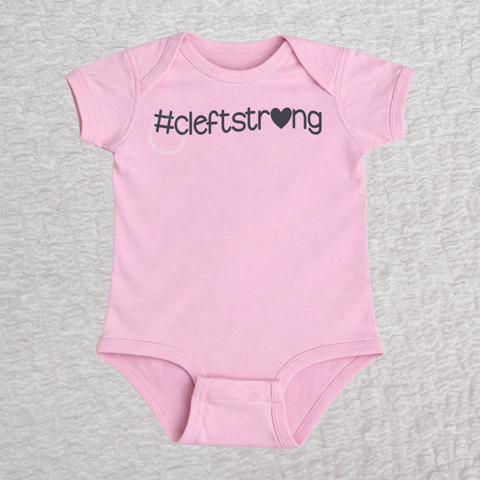 Cleftstrong Heart short sleeve baby bodysuit in pink featuring a pink Cleftstrong heart design