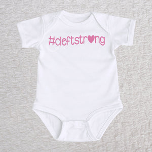 Cleftstrong Heart short sleeve baby bodysuit in white featuring a pink Cleftstrong heart design