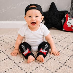 Baby wearing a white short sleeve bodysuit with Guitar baby leg warmers