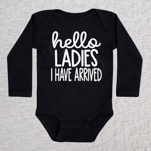 Hello Ladies I Have Arrived long sleeve baby bodysuit in black with playful typography design