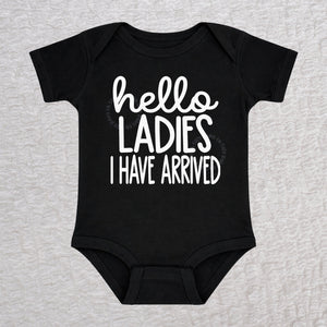 Hello Ladies I Have Arrived baby bodysuit in black with playful typography design