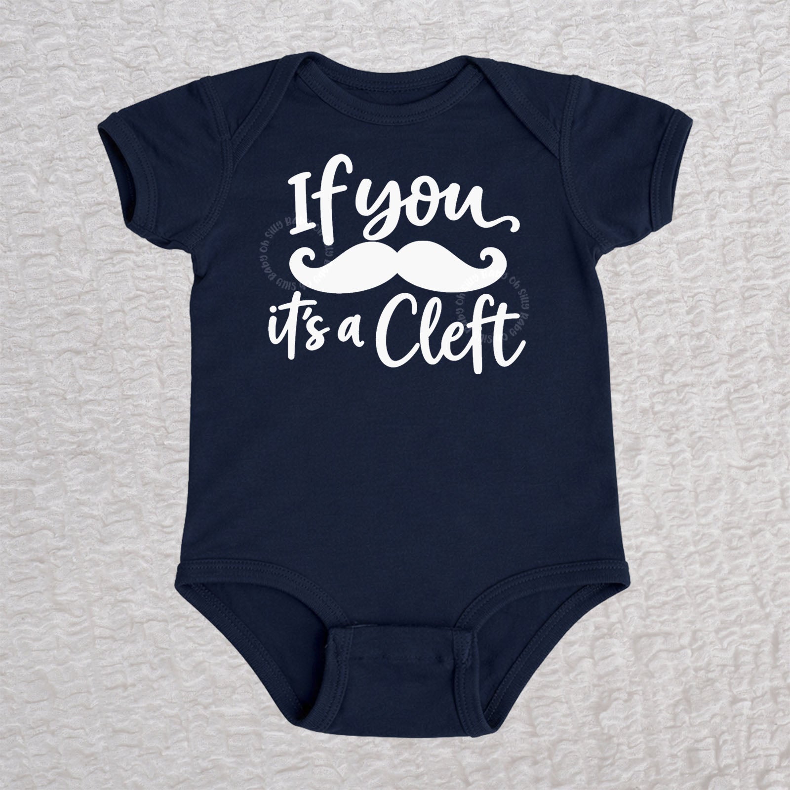 If You Mustache It's A Cleft short sleeve baby bodysuit in navy with mustache design
