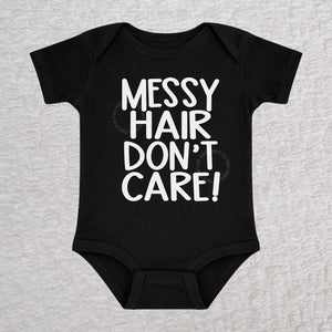 Messy Hair Don't Care short sleeve baby bodysuit in black with playful typography design