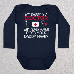 My Daddy Is a Doctor long sleeve baby bodysuit in navy featuring a reflex hammer, doctor's bag, and stethoscope design
