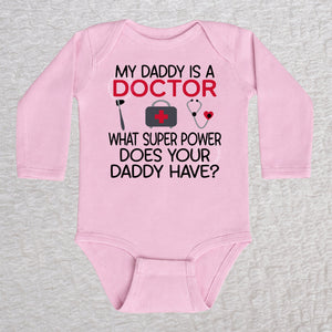 My Daddy Is a Doctor long sleeve baby bodysuit in pink featuring a reflex hammer, doctor's bag, and stethoscope design