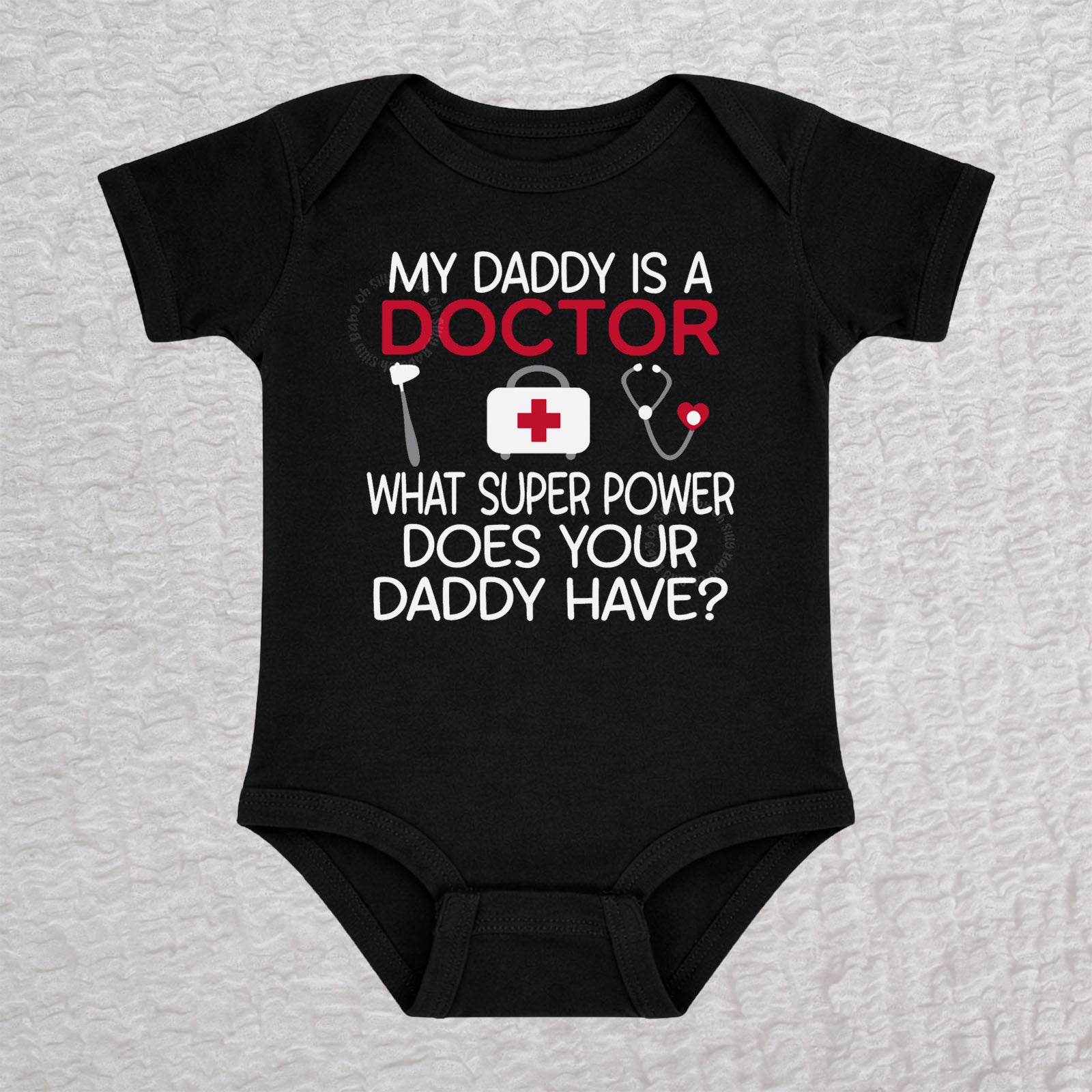 My Daddy Is a Doctor short sleeve baby bodysuit in black featuring a reflex hammer, doctor's bag, and stethoscope design