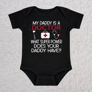 My Daddy Is a Doctor short sleeve baby bodysuit in black featuring a reflex hammer, doctor's bag, and stethoscope design