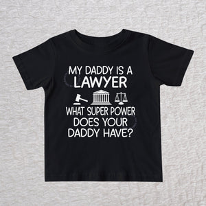 My Daddy Is a Lawyer unisex baby and toddler t-shirt in black featuring a gavel, courthouse, and scales of justice design
