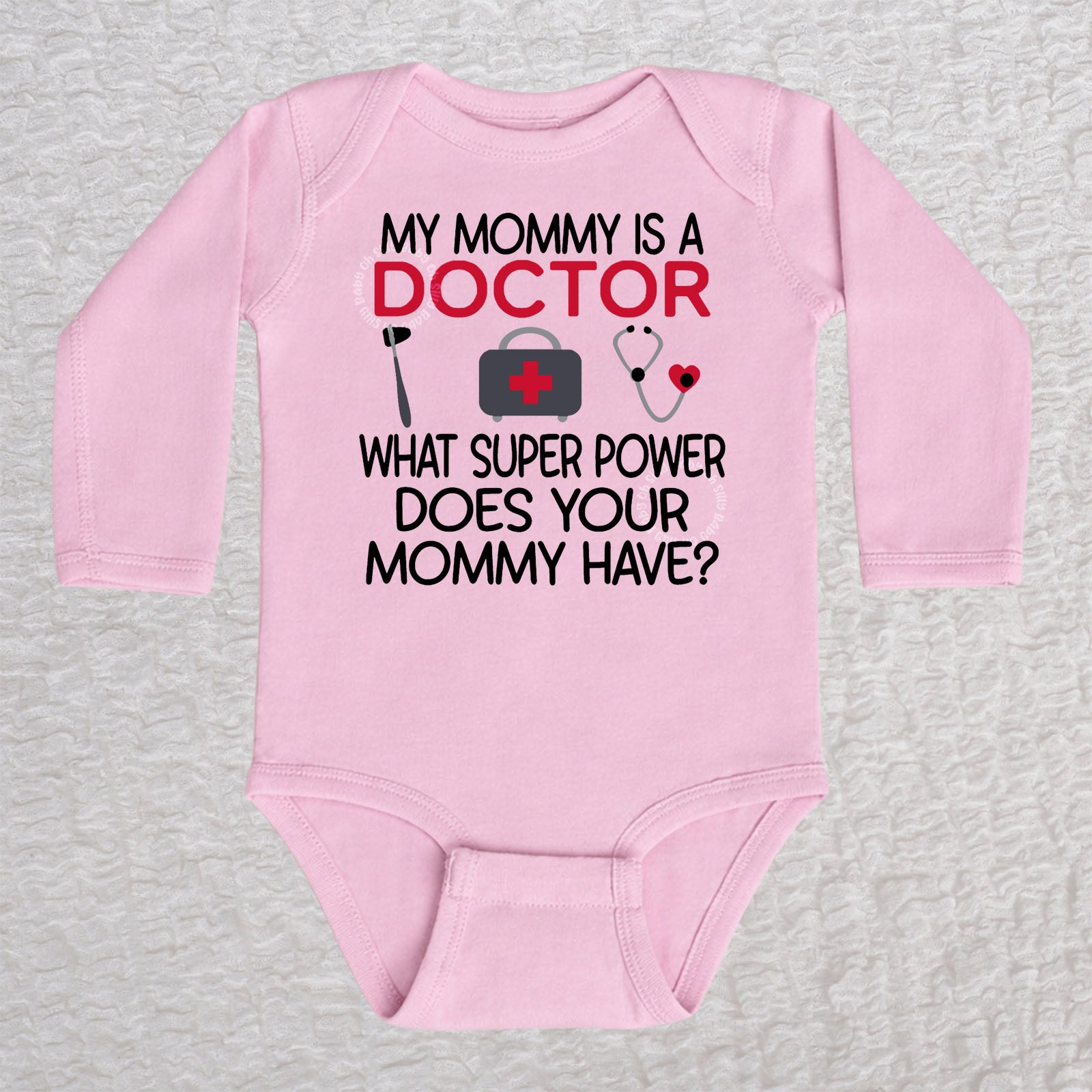 My Mommy Is a Doctor long sleeve baby bodysuit in pink featuring a reflex hammer, doctor's bag, and stethoscope design