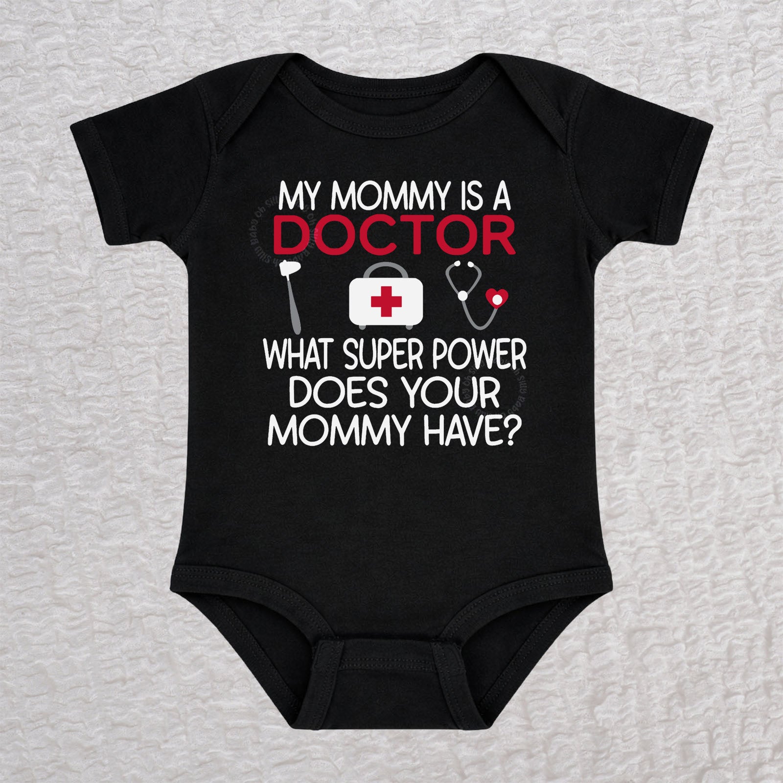 My Mommy Is a Doctor short sleeve baby bodysuit in black featuring a reflex hammer, doctor's bag, and stethoscope design