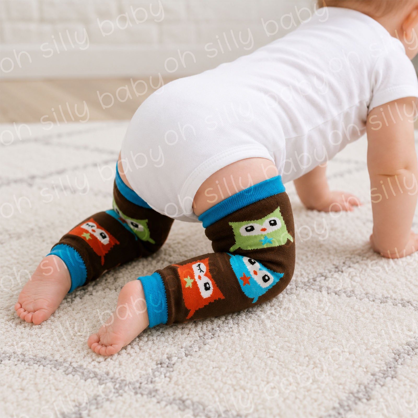 Baby crawling in a white short sleeve bodysuit wearing Owl baby leg warmers