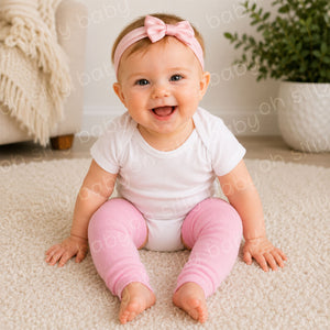 Baby girl wearing a white short sleeve bodysuit with Perfectly Pink baby leg warmers