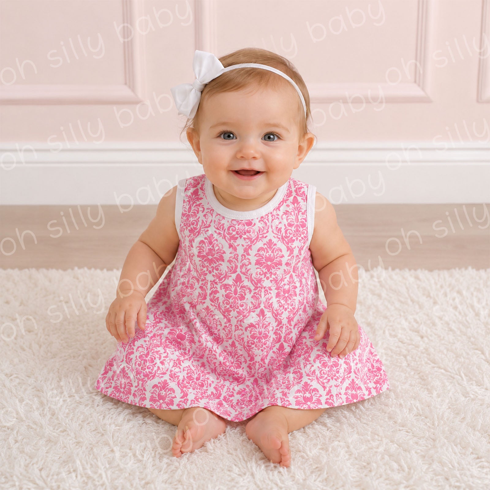 Baby girl wearing a Pink Damask Print Grow With Me Dress made from 100% cotton