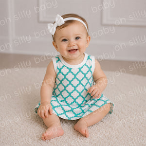 Baby girl wearing a Quatrefoil Print Grow With Me Dress made from 100% cotton