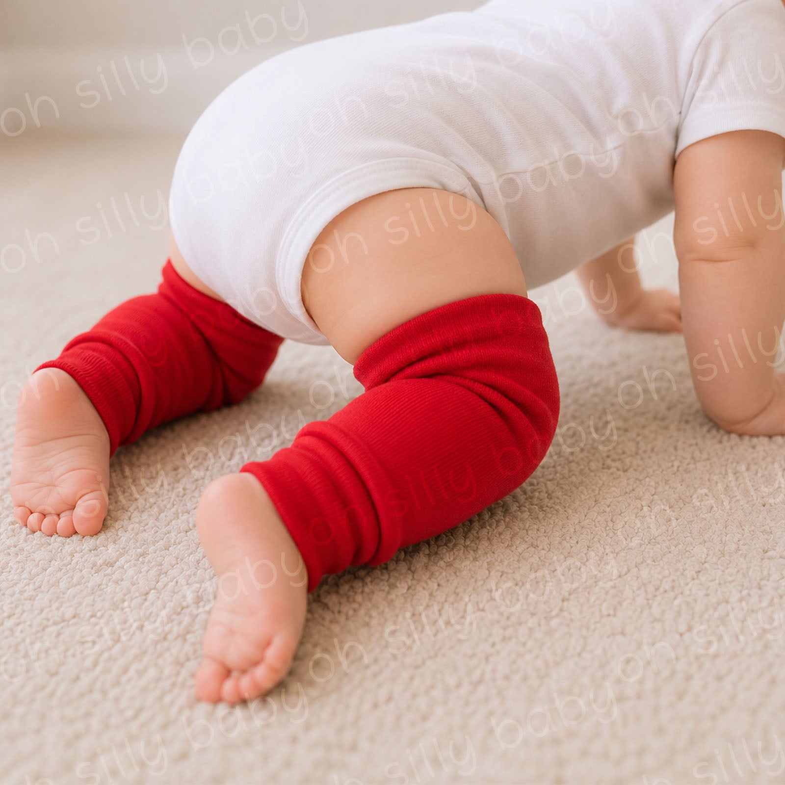 Close-up of a crawling baby wearing red baby leg warmers with a white baby bodysuit
