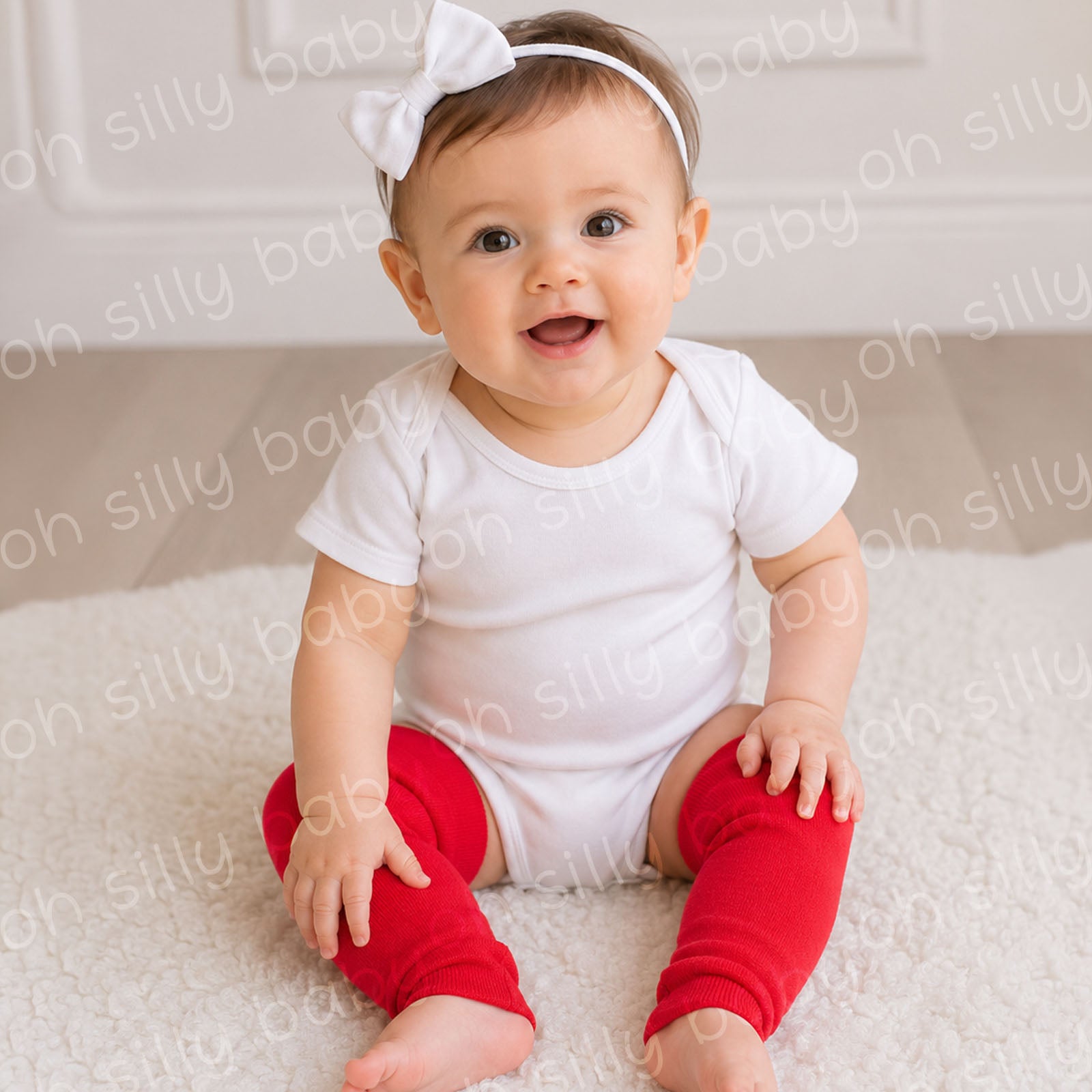 Baby wearing red baby leg warmers with a white bodysuit sitting on a soft rug