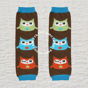Owl baby leg warmers with a colorful owl pattern on a brown background